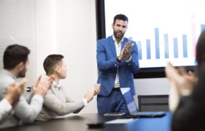 A man uses audio visual technology in presenting in front of a team