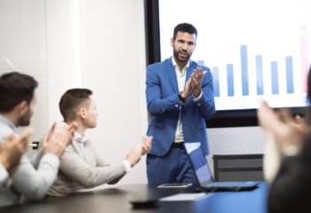 A man uses audio visual technology in presenting in front of a team