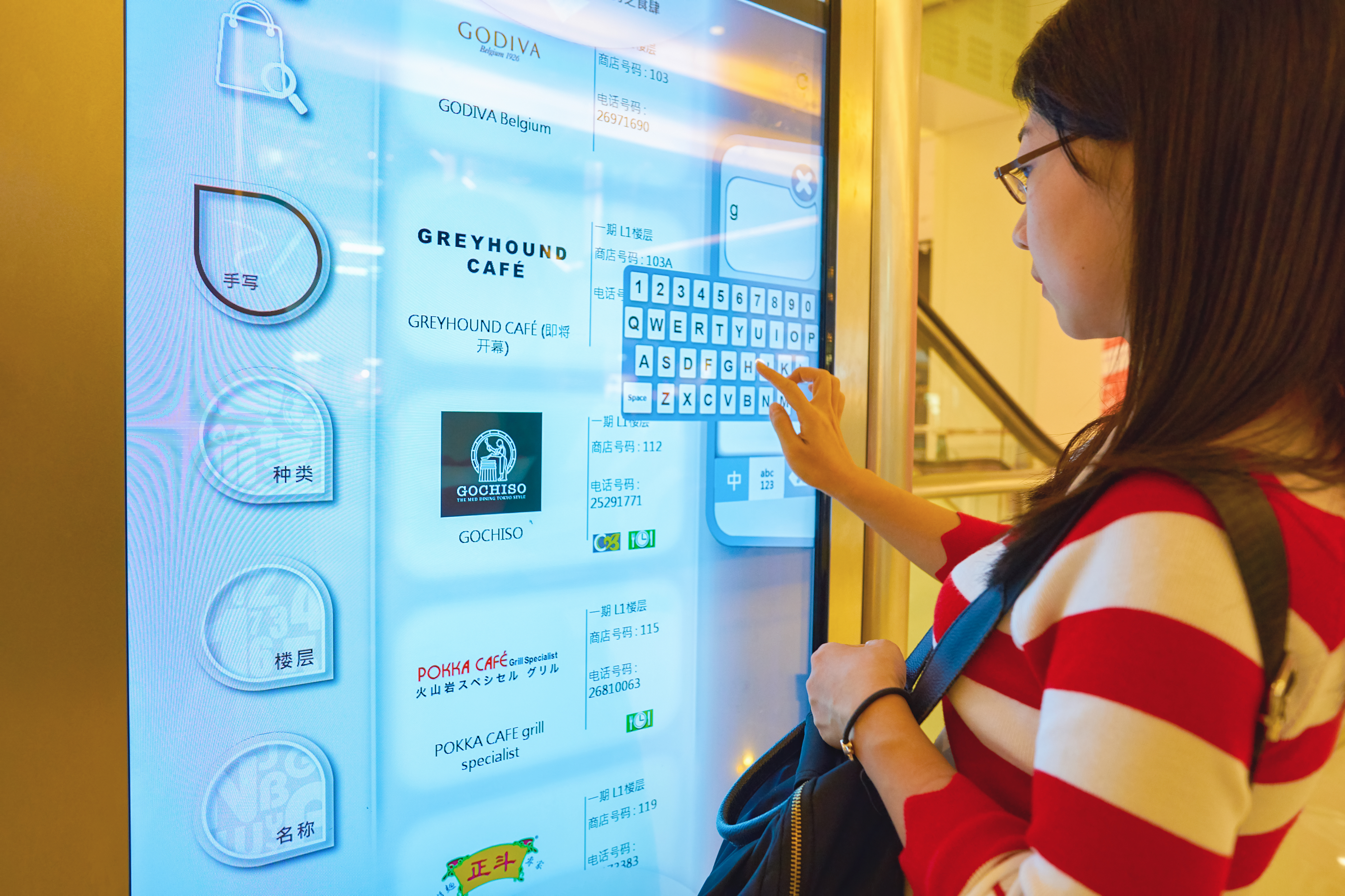 Woman using an interactive digital signage at a shopping mall